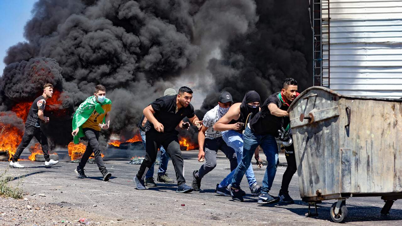 Palestijnse betogers steken autobanden in brand tijdens een confrontatie met Israëlische troepen op de Westelijke Jordaanoever.