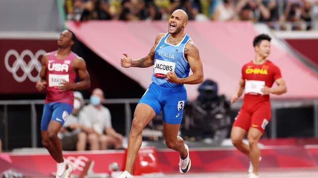 Marcell Jacobs komt juichend over de streep in het olympisch stadion in Tokio.