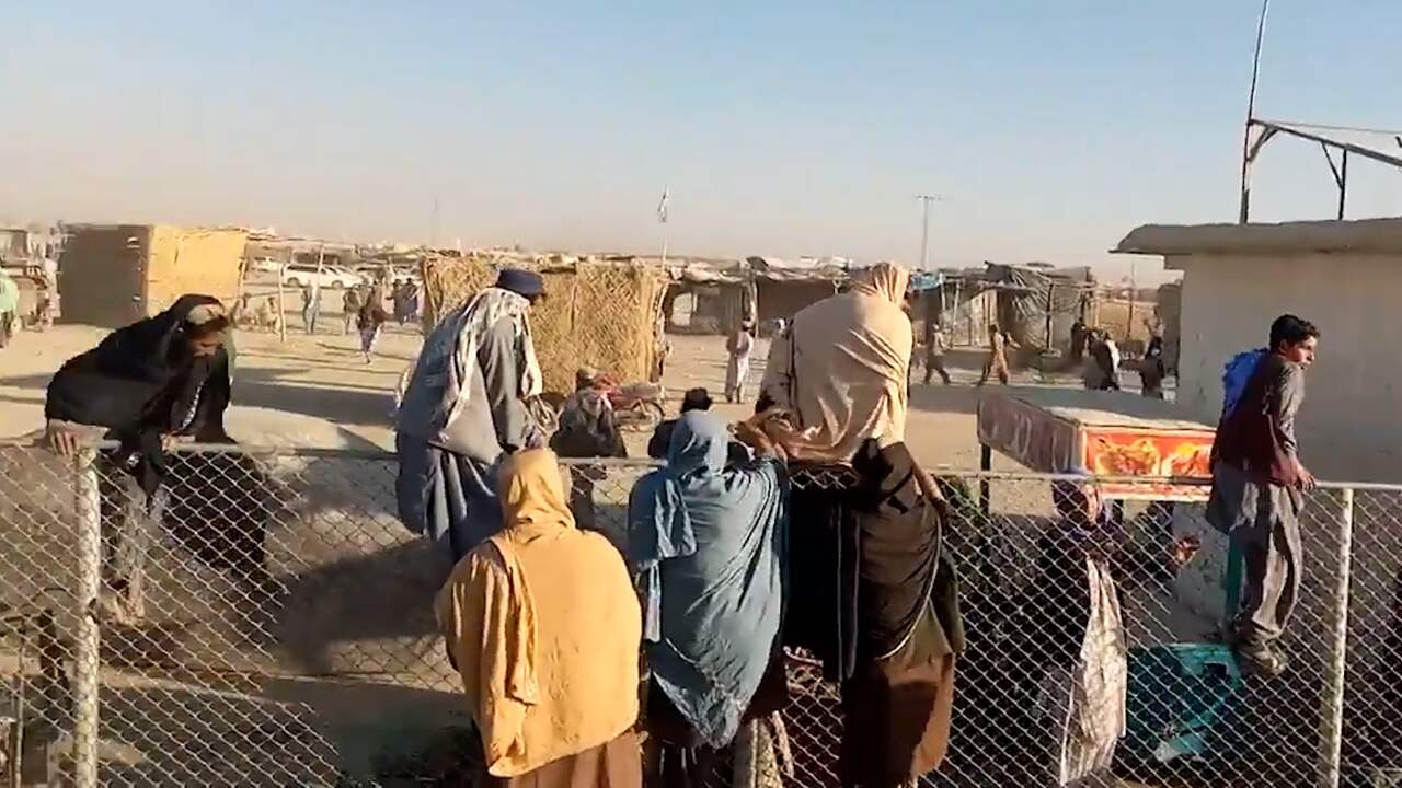 Beeld uit video: Gestrande Afghanen klimmen massaal grenshek naar Pakistan over