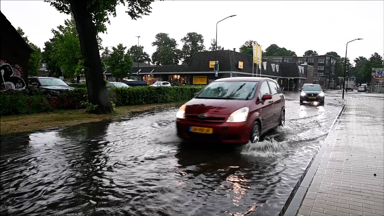 Beeld uit video: Auto's rijden door ondergelopen straat na onweersbuien in het land
