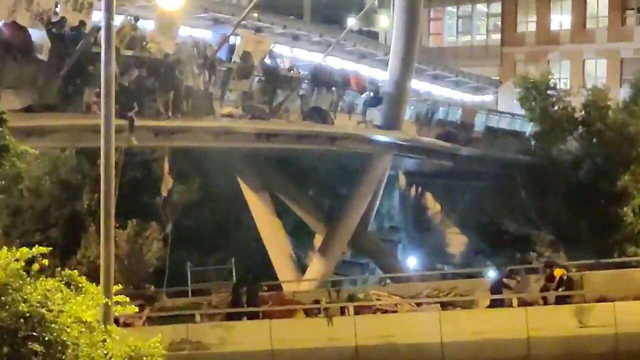 Demonstranten abseilen van omsingelde brug in Hongkong