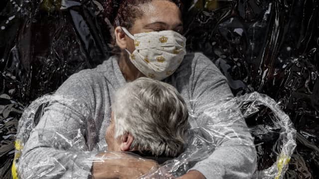 The Brazilian Rosa (85) receives her first hug in five months, thanks to a so-called 'cuddly curtain', from a nurse in the home where she lives.