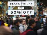Shoppers pass a promotional sign for 'Black Friday' sales discounts on Oxford Street in London, on November 24, 2017. Black Friday is a sales offer originating from the US where retailers slash prices on the day after the Thanksgiving holiday. In the UK it is used as a marketing device to entice Christmas shoppers with the discounts at stores often lasting for a week. / AFP PHOTO / Daniel LEAL-OLIVAS