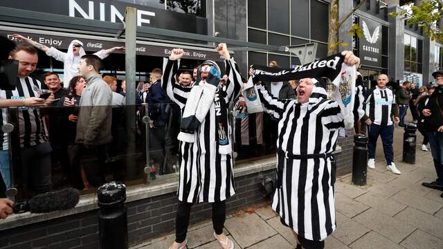 Buiten het stadion zijn supporters in gewaden in de clubkleuren te zien.