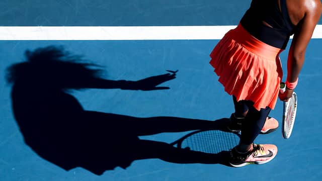 Een insect landt op de hand van Naomi Osaka, zoals in haar schaduw te zien is.