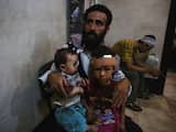 Een Syrische man wacht met zijn kinderen op behandeling in een ziekenhuis in Douma, ten oosten van Damascus.