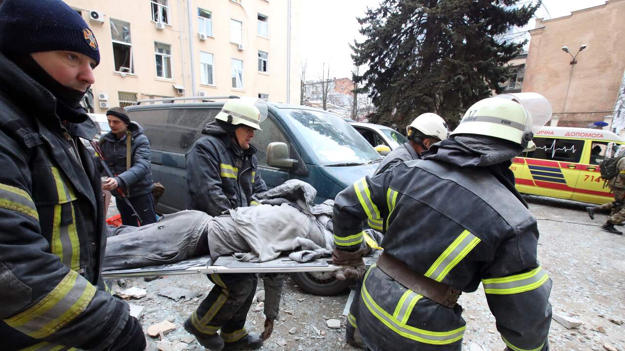 Reddingswerkers met een gewonde persoon na Russische beschietingen in Kharkiv