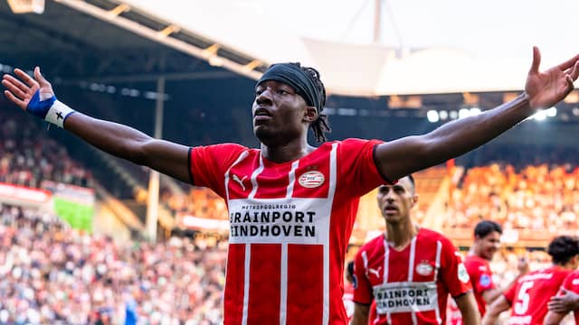 Noni Madueke spreidt zijn armen na zijn openingstreffer voor PSV.