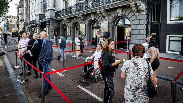 Voor het theater verzamelen zich de eerste mensen voor hun eerbetoon aan De Vries.