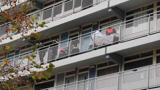 Hulpverleners helpen neergestoken vrouw op galerij van flat in Soest