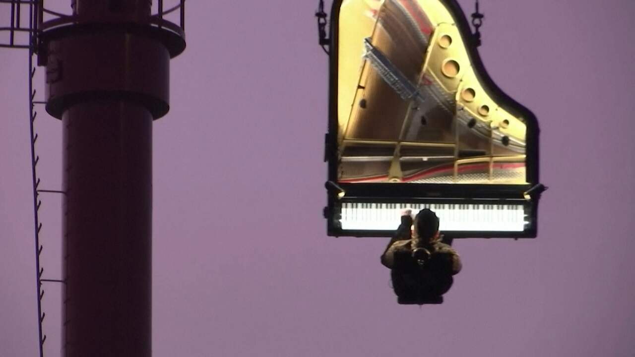 Pianist geeft concert bungelend aan hijskraan in München